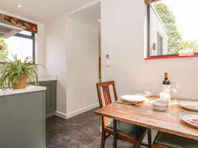 a dining room with a wooden table and chairs at Brow Wood Cabin in Penrith
