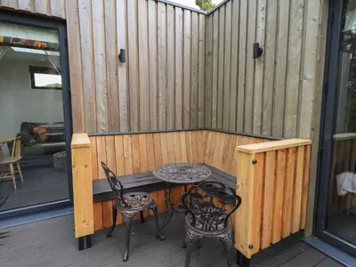 a patio with a table and chairs on a deck at Bluebell Cabin in Penrith
