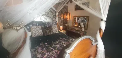 a bedroom with a bed with a canopy at Kirkcroft Guest House in Gretna