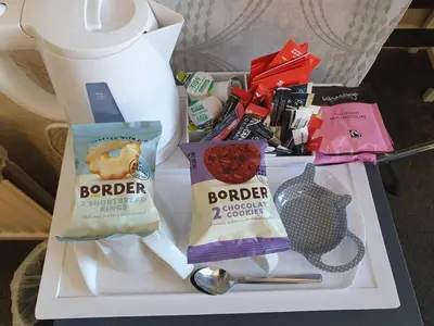 a tray with two bags of food and a spoon at Kirkcroft Guest House in Gretna