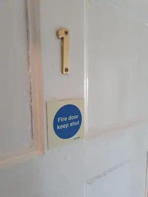 a fire door keep sing sticker on a bathroom door at Kirkcroft Guest House in Gretna