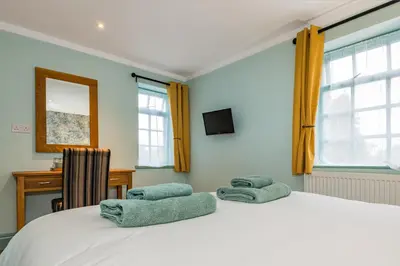 a bedroom with a bed with two pillows on it at The Queens in Carlisle