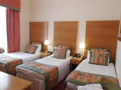 a hotel room with two beds and two lamps at Horizon Hotel in Ayr