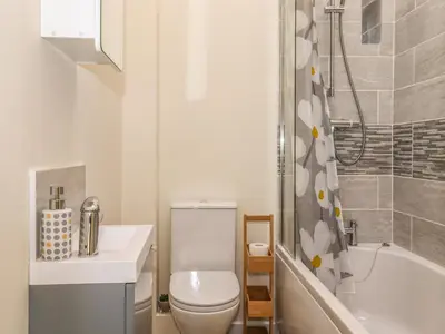 a bathroom with a toilet and a sink and a tub at The Granary in Wigton