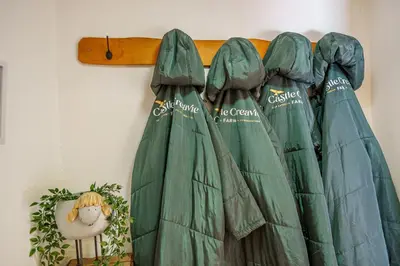a group of green curtains hanging on a wall at The Haybarn in Dundrennan