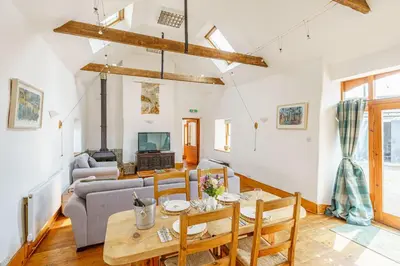 a living room with a table and a couch at The Haybarn in Dundrennan