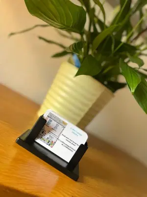 a cell phone sitting on a table next to a potted plant at Cosy Seaside Cottage in Allonby
