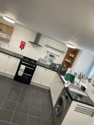 a kitchen with a washing machine in the middle of it at Cosy Seaside Cottage in Allonby