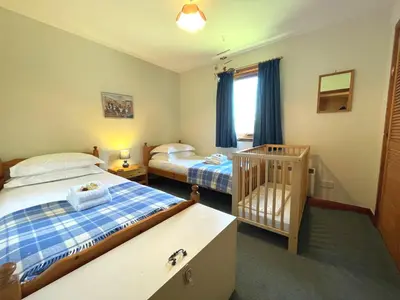 a bedroom with two beds and a crib in it at Beautiful Golf and Beach Lodge in Stunning Location - Pass the Keys in Dalbeattie
