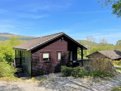 a small wooden cabin with a roof at Beautiful Golf and Beach Lodge in Stunning Location - Pass the Keys in Dalbeattie