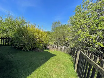 a wooden fence in a yard with trees and grass at Beautiful Golf and Beach Lodge in Stunning Location - Pass the Keys in Dalbeattie