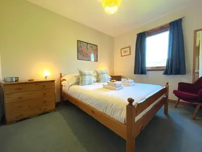 a bedroom with a bed and a dresser and a window at Beautiful Golf and Beach Lodge in Stunning Location - Pass the Keys in Dalbeattie