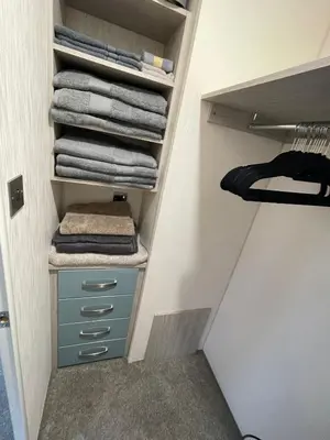 a walk in closet with blue drawers and towels at Lake District Luxury Lodge in Plumbland