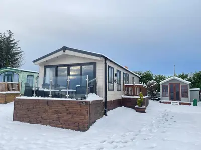 a house in the snow with chairs in it at Lake District Luxury Lodge in Plumbland