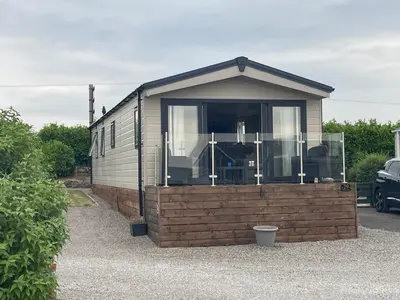 a tiny house with a large window in a parking lot at Lake District Luxury Lodge in Plumbland