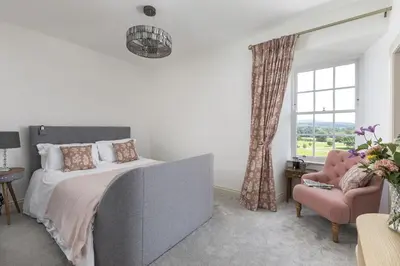 a bedroom with a bed and a chair and a window at East Wing in Thornhill