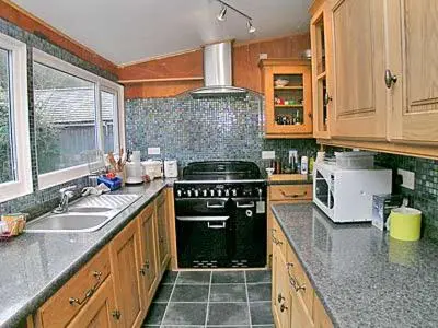 a kitchen with a black stove and a sink at Braemar in Lendalfoot