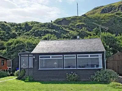 a small house in front of a mountain at Braemar in Lendalfoot