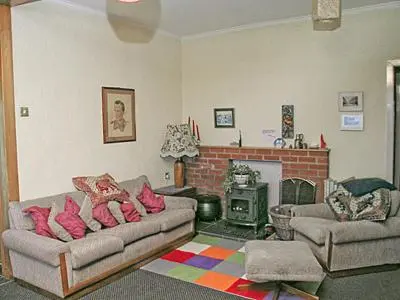 a living room with two couches and a fireplace at Braemar in Lendalfoot