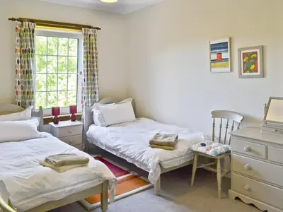 a bedroom with two twin beds and a window at The Cottage in Girvan