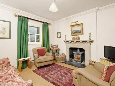 a living room with a fireplace and green curtains at Gardener's Cottage-Uxt in Corsock