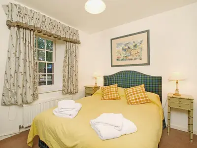 a bedroom with a bed with towels on it at Stables Cottage-Uud in Corsock