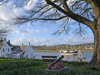 a bench next to a body of water with a boat at Stables Cottage-Uud in Corsock