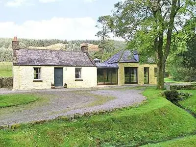 an old house with a gravel driveway in front of it at Marwhin Cottage - Swws in Kirkpatrick Durham