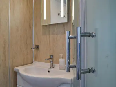 a bathroom with a sink and a mirror at Swallow Lodge in Carsphairn