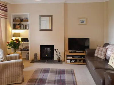 a living room with a couch and a flat screen tv at Burnbank in Kirkgunzeon
