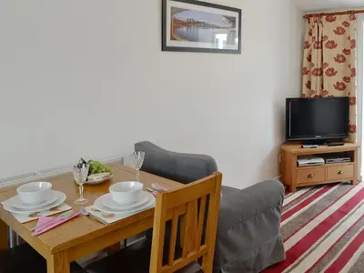 a living room with a table and a chair and a television at Barnhill Bothy in Moffat