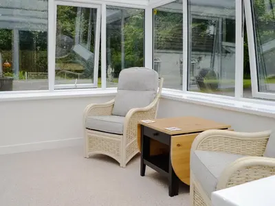 a room with a chair and a desk and windows at Barnhill Bothy in Moffat