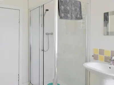 a white bathroom with a shower and a sink at Burnfoot Of Cluden in Holywood
