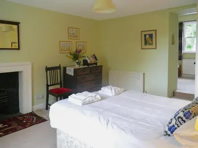 a bedroom with a large white bed and a fireplace at Little Boreland in Gatehouse of Fleet