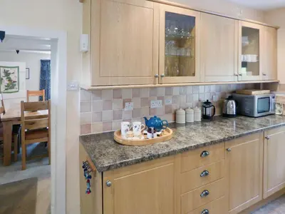 a kitchen with wooden cabinets and a counter top at Little Boreland in Gatehouse of Fleet