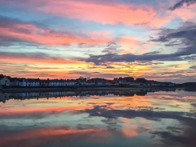 a sunset over a body of water with a cloudy sky at Seaview in Garlieston