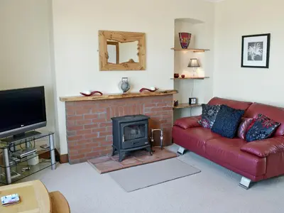 a living room with a red couch and a fireplace at Winloma in Port William