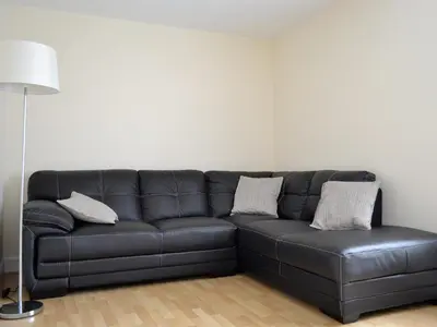a black leather couch in a living room with a lamp at Sea-Esta - 28175 in Port William