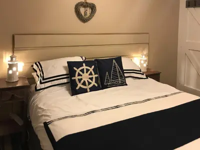 a bed with black and white pillows on it at Driftwood in Mainsriddle