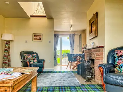 a living room with chairs and a fireplace at Gigha in Drummore