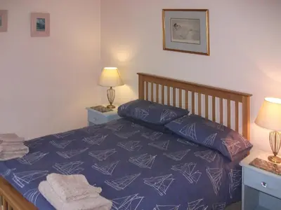 a bedroom with a bed with blue sheets and pillows at Gigha in Drummore