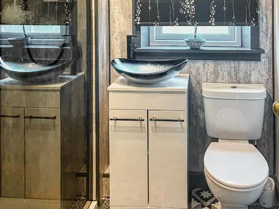 a bathroom with a toilet and a sink at Gigha in Drummore