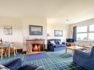 a living room with couches and a fireplace at Jura in Drummore