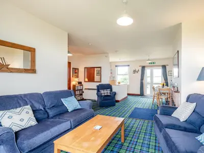 a living room with a blue couch and a table at Jura in Drummore