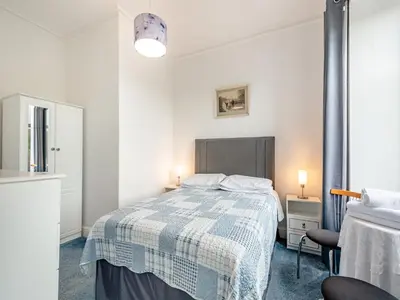a bedroom with a bed with a blue and white blanket at Braefield in Portpatrick