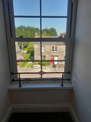 a window with a view of a building through it at Kirkcudbright Holiday Apartments - Apartment G in Kirkcudbright