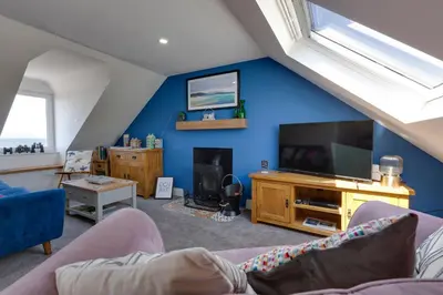 a living room with a blue wall and a tv at Westview in Newton Stewart