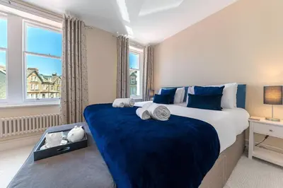a bedroom with a large bed and a large window at Hazelgrove, Ratcliffe Place, Keswick in Keswick