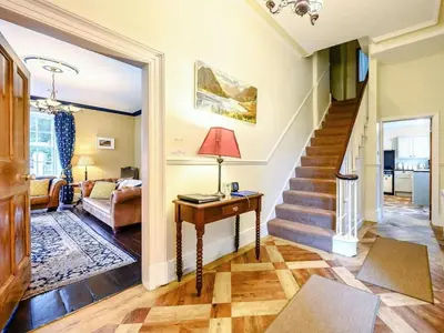 a living room with a staircase and a table at Oak Lodge in Keswick