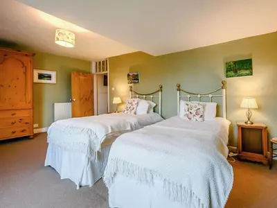 a bedroom with two beds with white sheets at Oak Lodge in Keswick